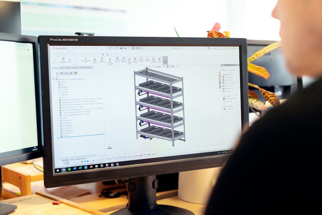 Engineer working at a computer workstation reviewing system designs, representing AI system change management and version control processes